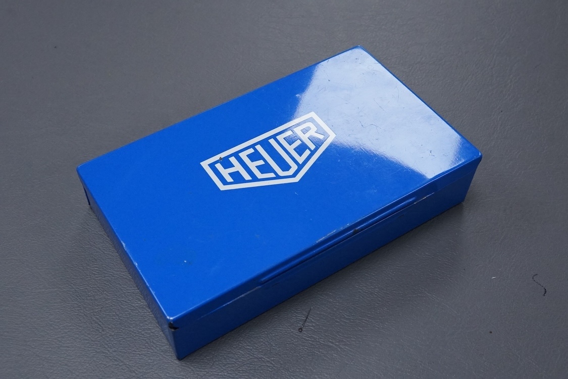 A 1970's steel cased Heuer Yacht Timer wrist stop watch, with polychrome dial, on a fabric strap, case diameter 52mm, with original Heuer tin box.